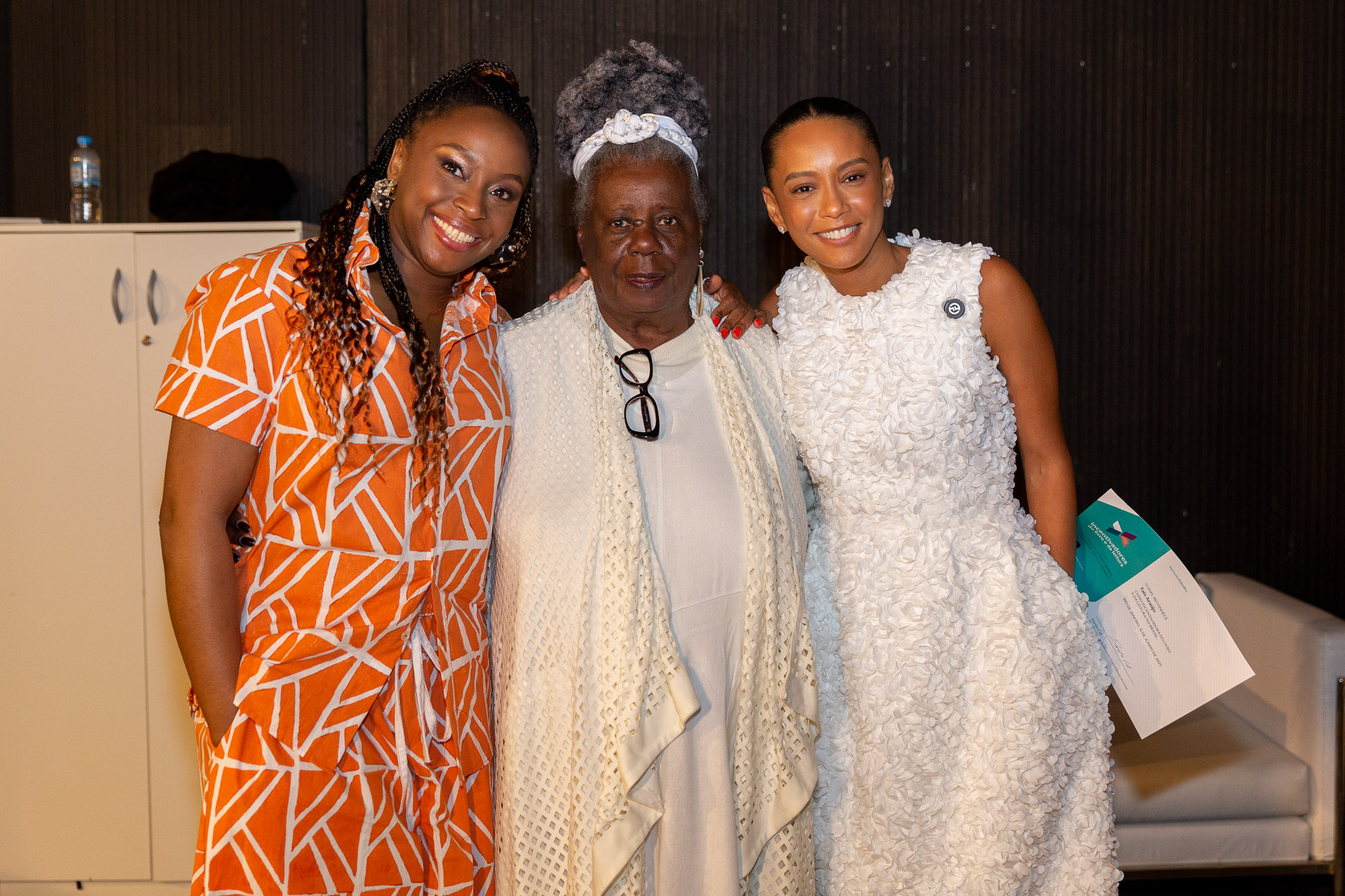 Taís Araújo, à direita, recebe o título das mãos de Conceição Evaristo (Centro), acompanhada da escritora nigeriana Chimamanda Ngozi Adichie